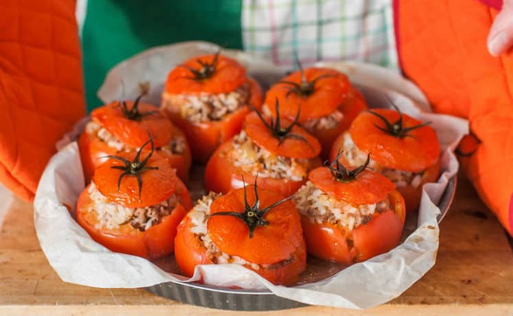 фаршированные помидоры с фаршем и рисом в форме для запекания, застеленной пергаментом