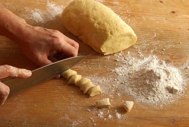 маленькие кусочки теста на столе с мукой