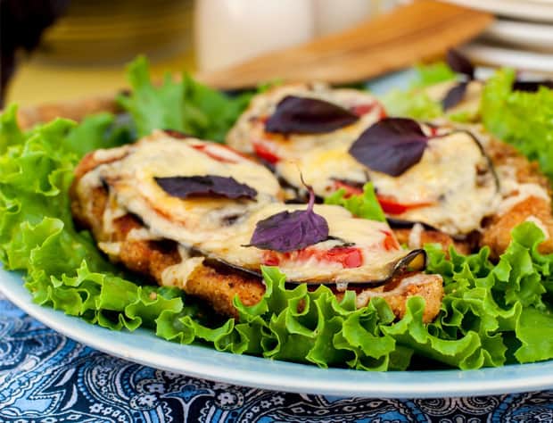 тарелка с курицей, баклажанами и помидорами с зеленью