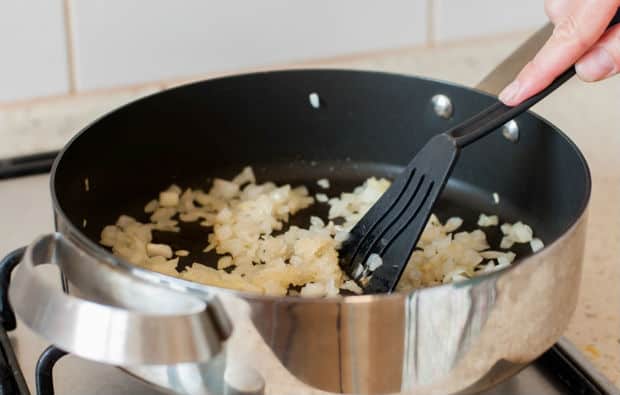 нарезанный лук в сотейнике с шумовкой
