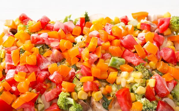 нарезанный желтый и красный перец с брокколями и кукурузойт в форме для запекания
