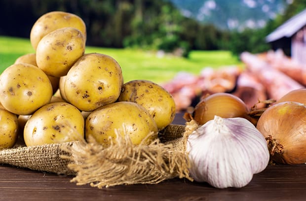 неочищенные картофель, лук и чеснок