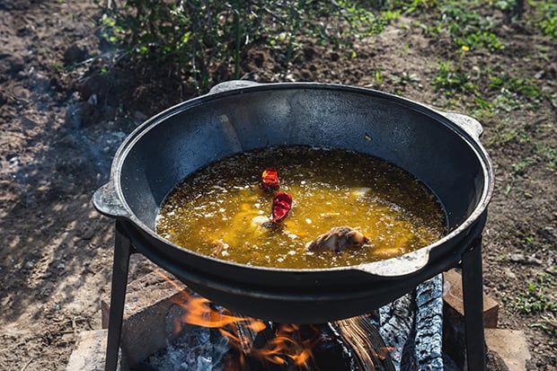 вода со специями и мясом в казане на костре