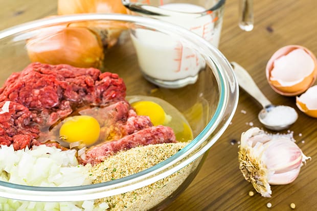 фарш с панировочными сухарями, яйцами и луком в миске
