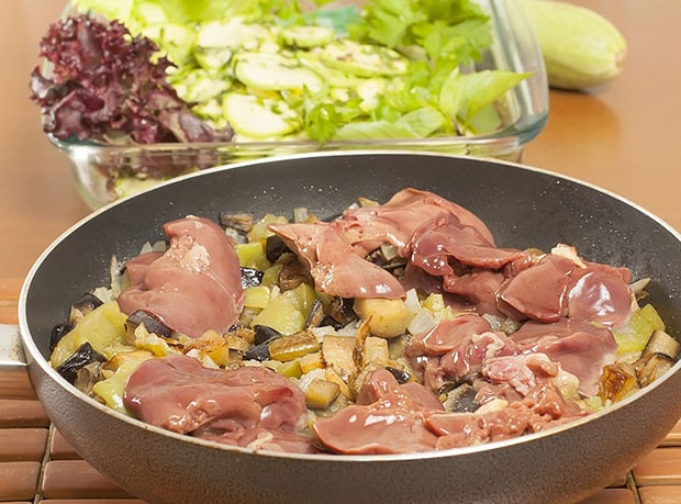 свежая куриная печень с овощами на сковороде