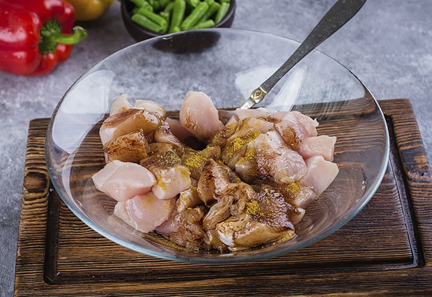 нарезанная куриная грудка со специями в мисочке