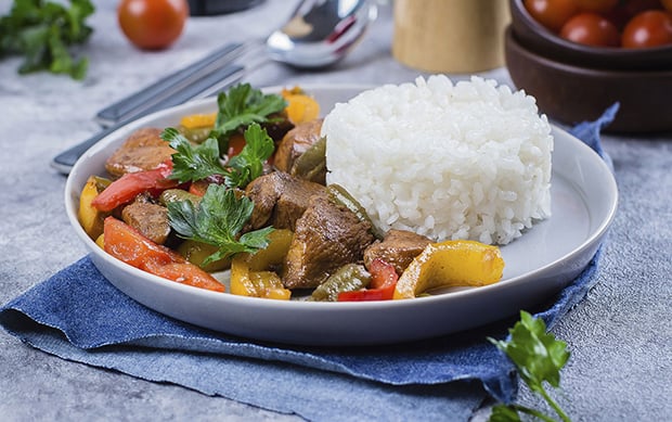 тушеные куриные грудки с овощами и рисом на тарелке